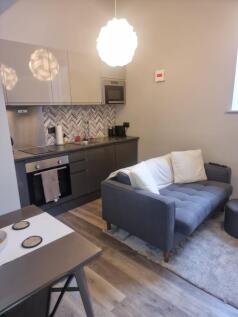 Modern open-plan living area with a compact kit...
