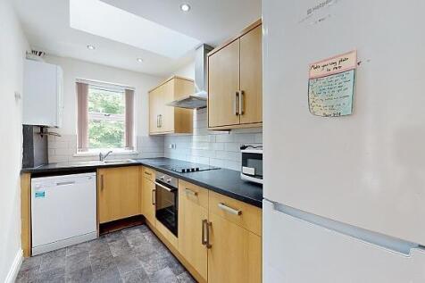 Bright modern galley kitchen with wooden cabine...