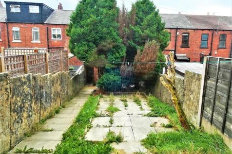 Rear garden with paved patio area, bordered by ...