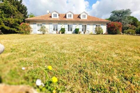 Une maison avec un toit en tuiles, entourée de ver