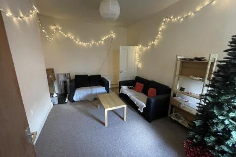 A cozy living room adorned with fairy lights, p...