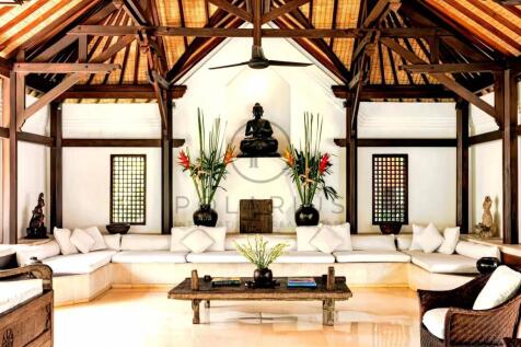 A luxurious tropical living room with wooden beams