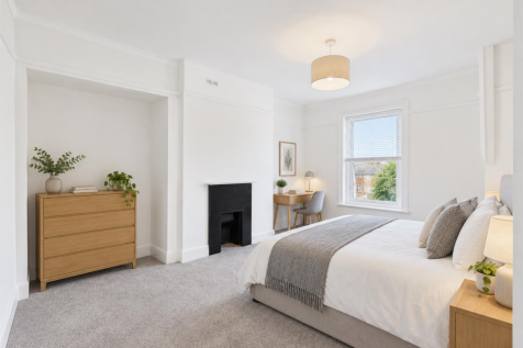 Bright rental bedroom with period fireplace.png