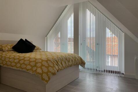 Bright modern bedroom with unique feature windo...