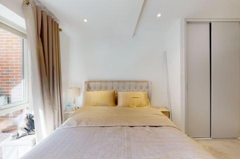 Bright bedroom with large window and storage...