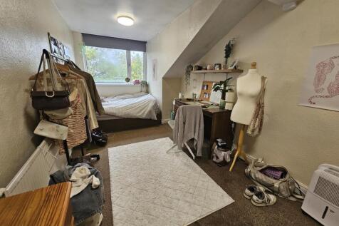 A cozy bedroom with a large window providing na...