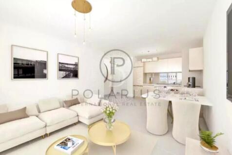 A modern, white living room with a cozy sofa, roun