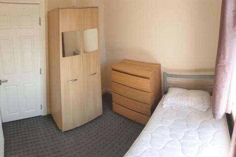 Bright, simply furnished bedroom with a single ...