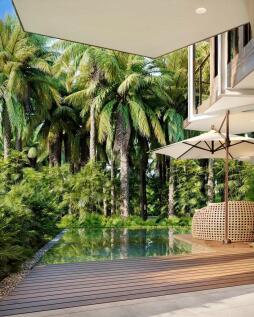 A modern patio with a wooden deck overlooks a tran