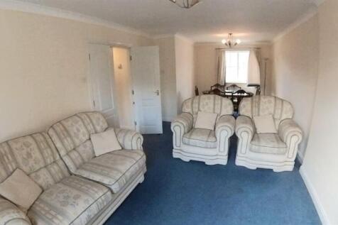 Bright, neutrally decorated living room with ma...