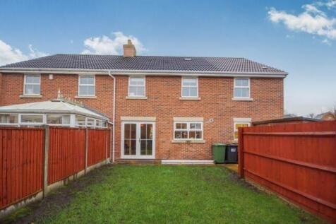 Well-kept rear garden with a lawn leading to a ...