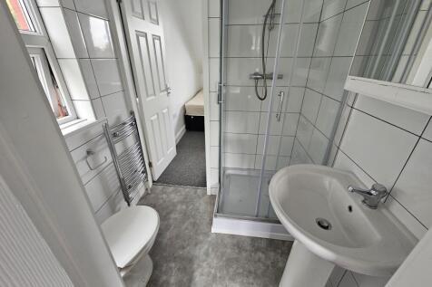 Bright and modern bathroom featuring a clear gl...