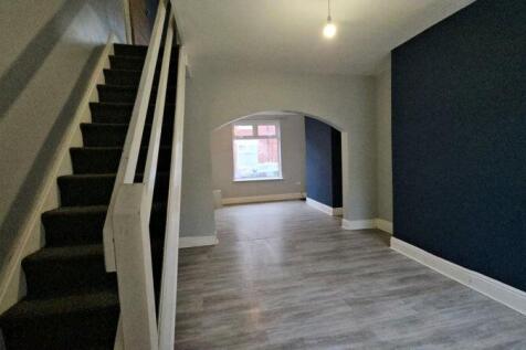 A clean and modern hallway featuring light wood...