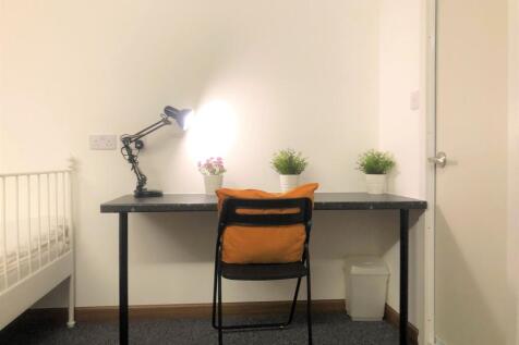 A simple, clean study area with a black desk an...