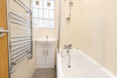 Bright bathroom with bath and heated towel rail...