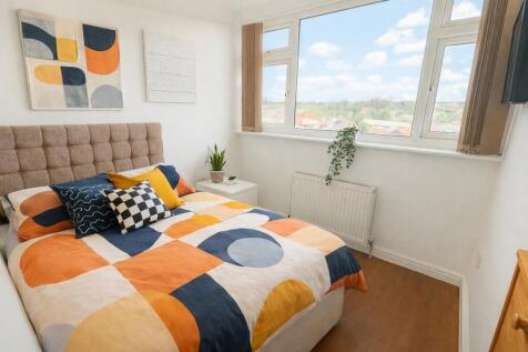 Bright double bedroom with colourful bedding an...