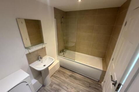 Modern bathroom suite with full bathtub and til...