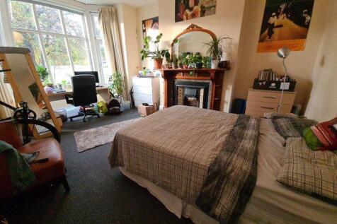 A spacious and well-lit master bedroom featurin...