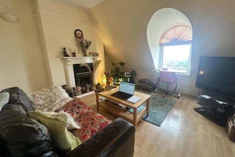 Cozy lounge with unique arched window and desk...