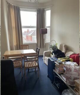 Bright bay-front living room with a dining tabl...