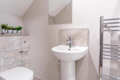 Bright, modern bathroom with a pedestal sink, c...