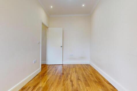 Bright, freshly painted single bedroom with war...