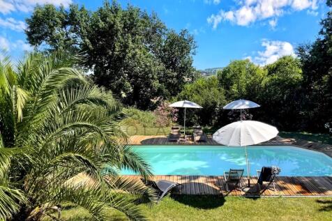 A tranquil outdoor scene features a swimming pool 