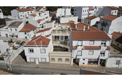 Drone aerial front photo showing Casa Loko modern villa project integrated into the traditional urban architecture of Lagoa Algarve.
