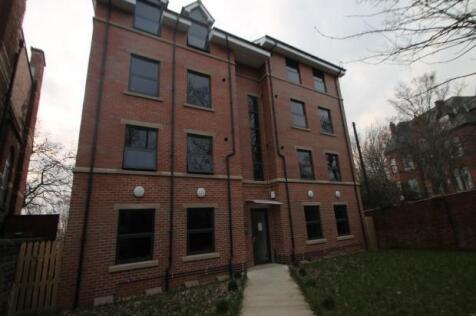 Well-kept brick building with lawned entrance...