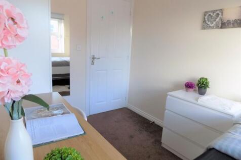 Bright, simply furnished bedroom with a tidy de...