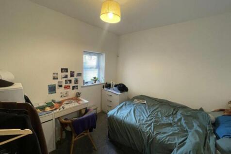 Bright, simply furnished bedroom with a double ...