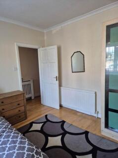 Bright bedroom with stylish wood floors and rug...