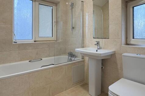 Bright, modern bathroom with a full bathtub, pe...