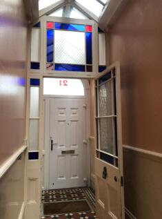 A clean and well-lit hallway leading to the ent...