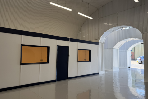 An empty arch with white lining and a WC cubicle to the front.