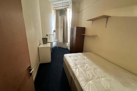 Narrow single bedroom with a mattress on a diva...