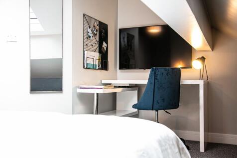 A modern bedroom featuring a cozy layout with a...