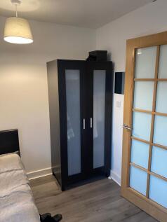 Neat bedroom corner with a modern black wardrob...
