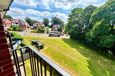 Bright balcony view over lush green lawns...