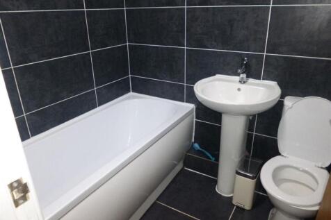 Modern bathroom with a white bathtub, pedestal ...
