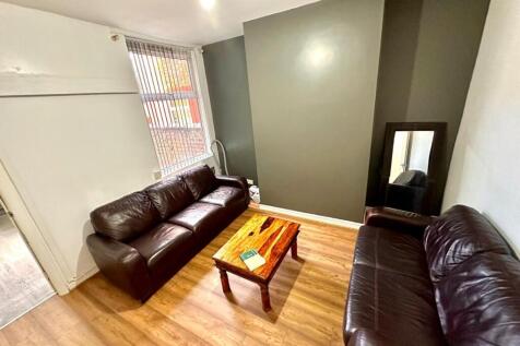 Bright furnished living room with two leather s...