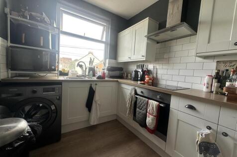 Modern kitchen with subway tiles and large wind...