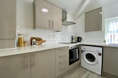 A modern and tidy kitchenette with ample storag...