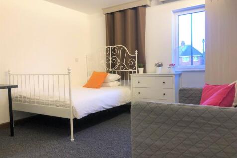 Bright and tidy bedroom featuring a white metal...