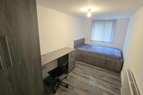 Modern bedroom with dedicated desk area and bed...