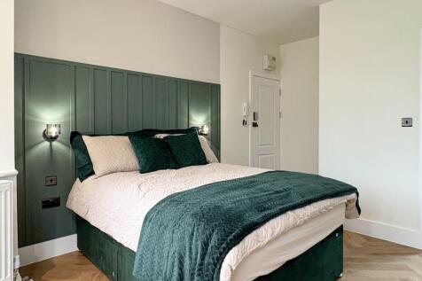 Bright, stylish double bedroom with a padded gr...