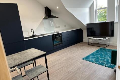 Modern open-plan kitchen-living area with sleek...