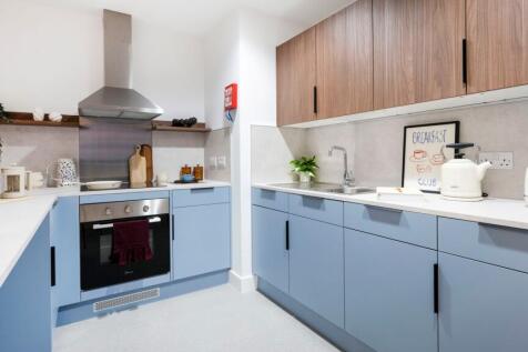 Modern fitted kitchen with pastel blue lower ca...
