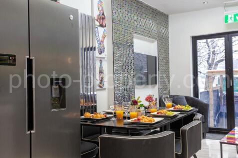 Sleek open-plan kitchen/dining area with a mode...
