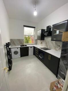 Modern, well-lit kitchen featuring sleek black ...